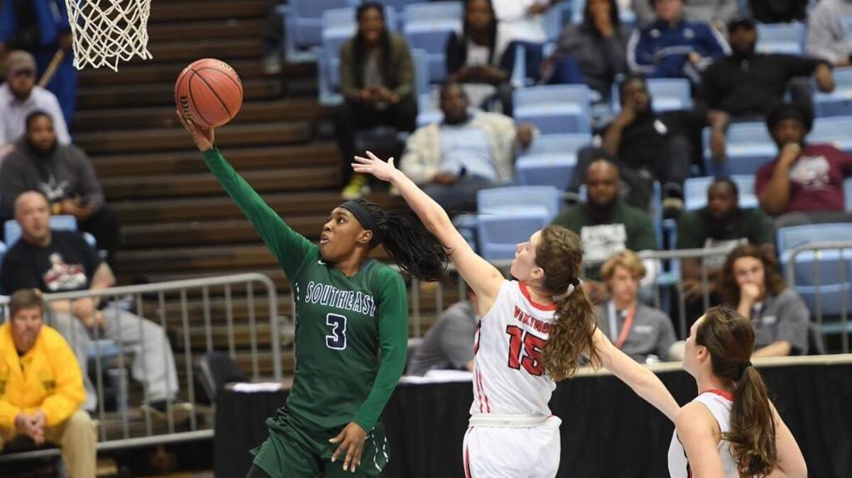Tamia Davis (3) of Southeast Raleigh scores with a layup against Reagan Kargo (15) of Northwest Guilford. The Southeast Bulldogs played the Northwest Guilford Vikings in a girls basketball game that counted for the NCHSAA 4A championship that took place at the UNC Dean Smith Center in Chapel Hill, N.C. on Saturday, March 10, 2018.