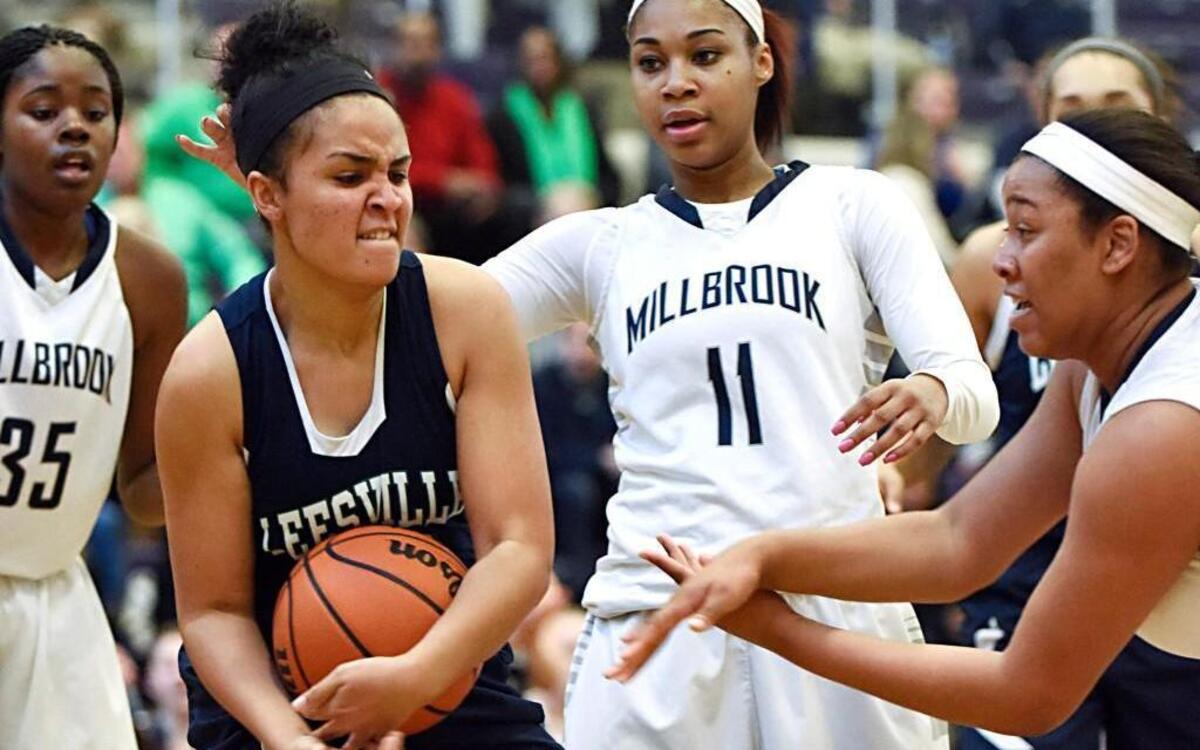 Leesville Road's Shelby Lattimore (22) fights for the ball with Millbrook's Dazia Powell (11) and Dominique Cross (55) in the CAP 8 championship in Raleigh, N.C. on Friday, February 19, 2016. Millbrook won 51-37.