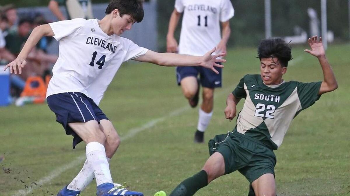 South Johnston’s Brian Ocampo (22) tries to make a tackle on Cleveland’s Ryan Metz (14).