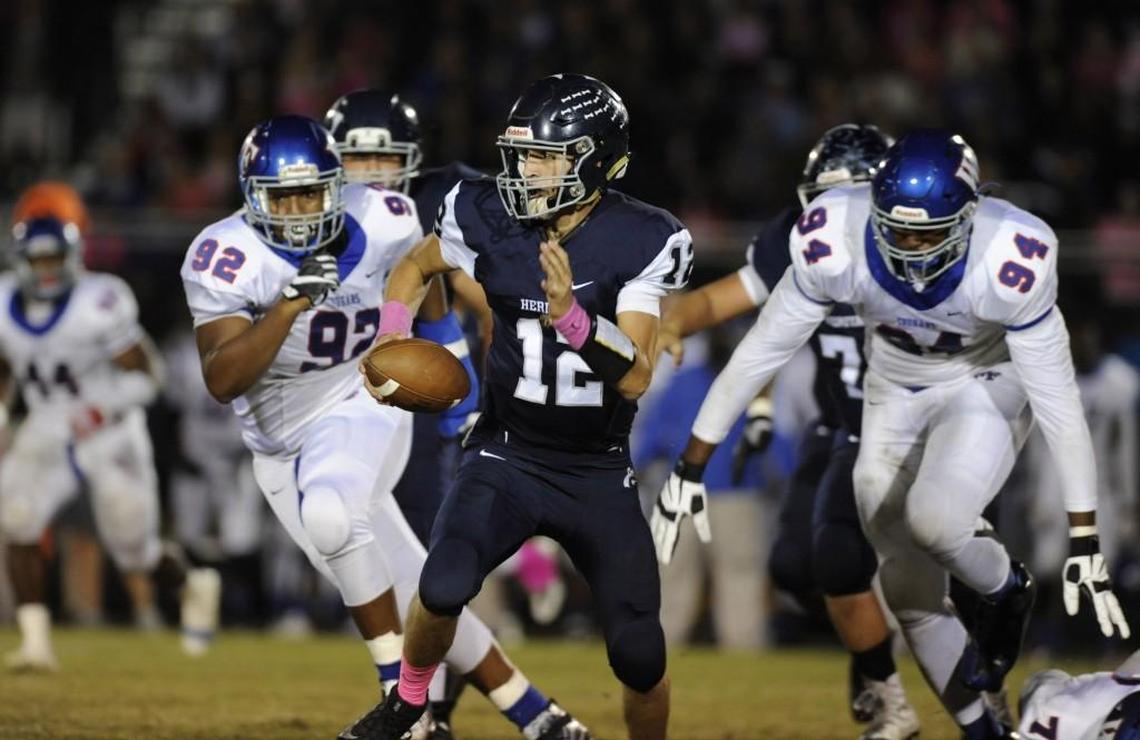 Heritage quarterback Gunnar Holmberg (12) is pursued by Wake Forest's Jaden Mckenzie (92) and Xach Gill (94) in Wake Forest, N.C. on Friday, October 14, 2016. Wake Forest won 26-13.