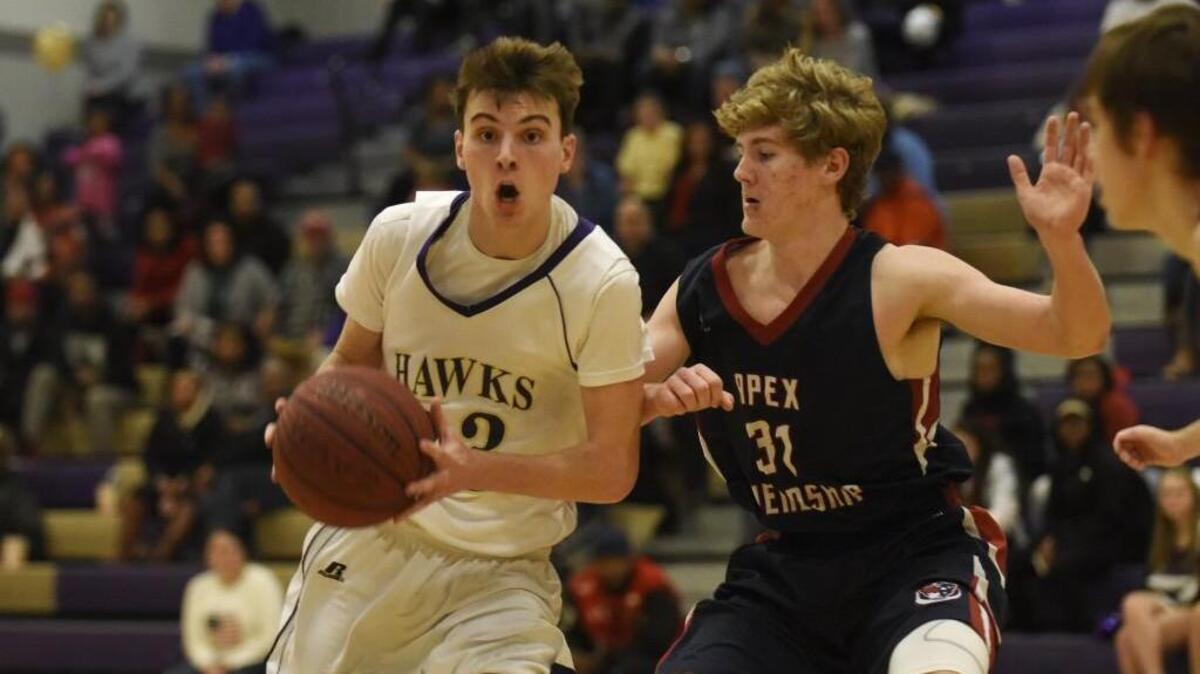 Holly Springs' Jake Kelsey (23) drives past Apex Friendship's Vincent Burlingame (31) in Holly Springs, N.C. on Friday, February 10, 2017. Holly Springs won 62-50.
