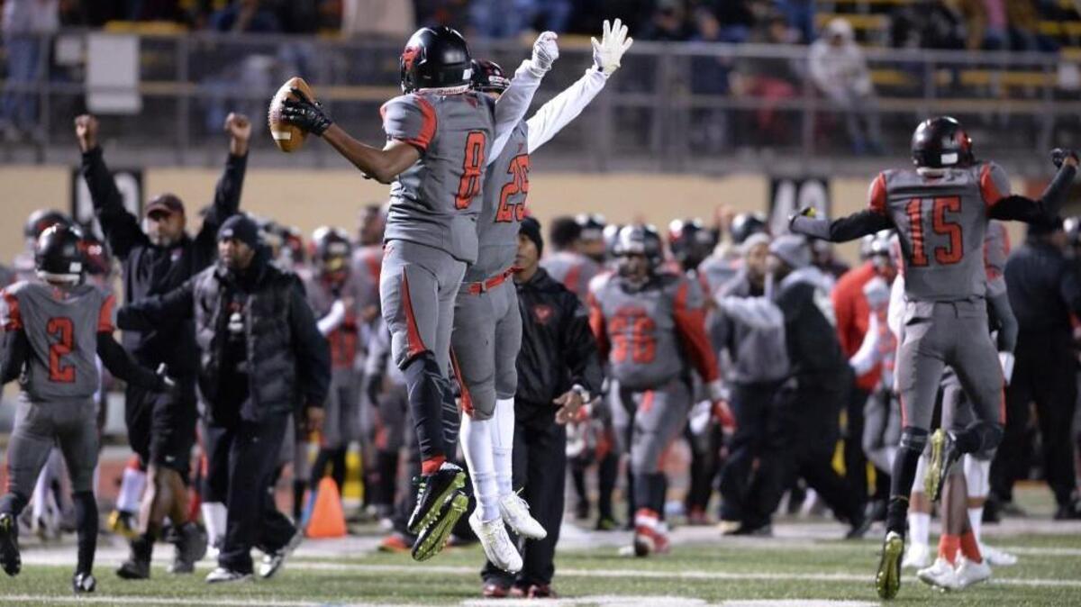 Jaekwon Amey (8) and Jaleel Scroggins (25) of Southern celebrate a defensive win for the Spartans. The Southern Spartans played the Orange Panthers at the Durham County Memorial Stadium in Durham, N.C. on Friday, November 20, 2015.