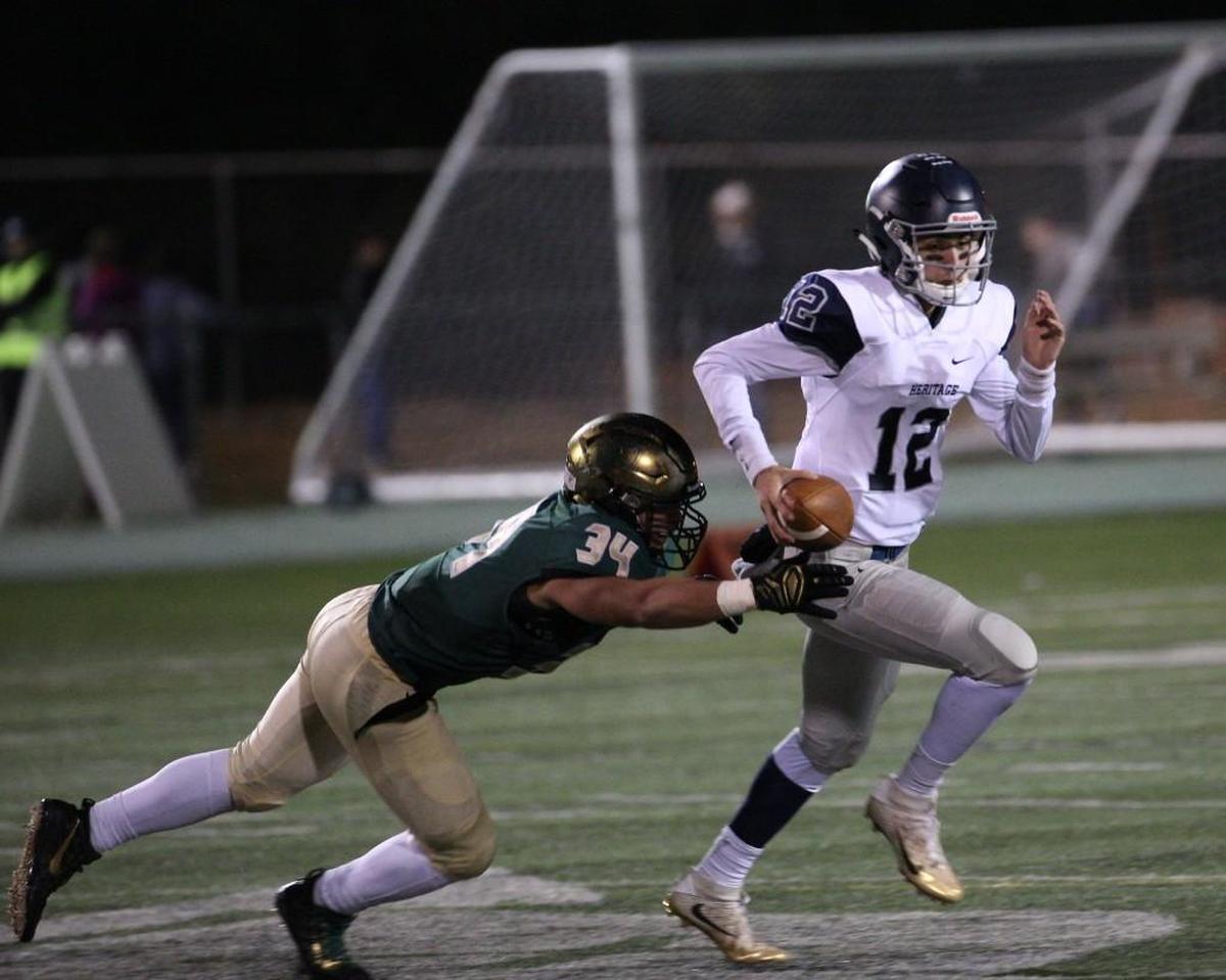 Cardinal Gibbons’ Jalen Brooks (34) dives for Heritage's Gunnar Holmberg (12) during the Cardinal Gibbons Crusaders football team has a home 2nd round playoff game vs. Heritage Huskies on Friday, November 17, 2017. Raleigh ,N.C.