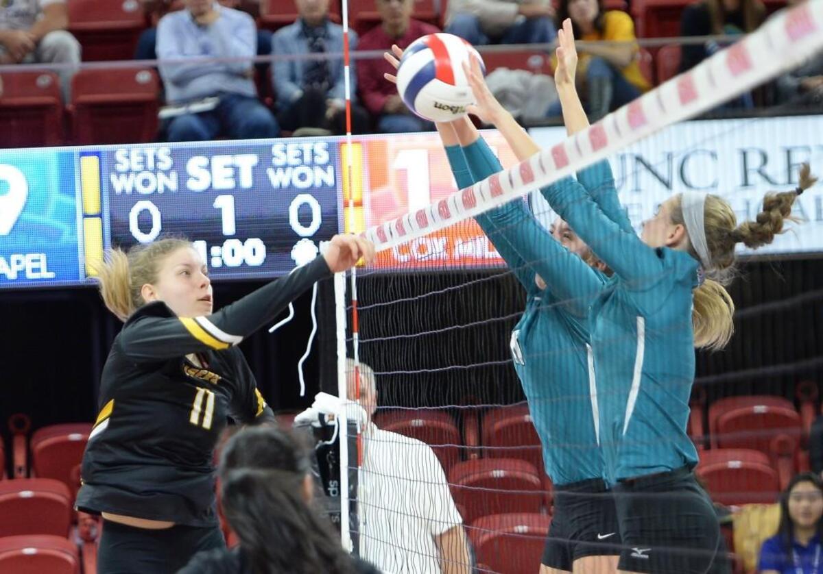 Courtney Zwikker (11) of Chapel Hill gets her shot blocked by Courtney Weber, center, and Alison Siersma, right, of Cox Mill. The Chapel Hill Tigers played the Cox Mill Chargers for the NCHSAA 3A volleyball championship that took place at the N.C. State Reynolds Coliseum in Raleigh, N.C. on Saturday, November 5, 2016. Cox Mill won 3-0.