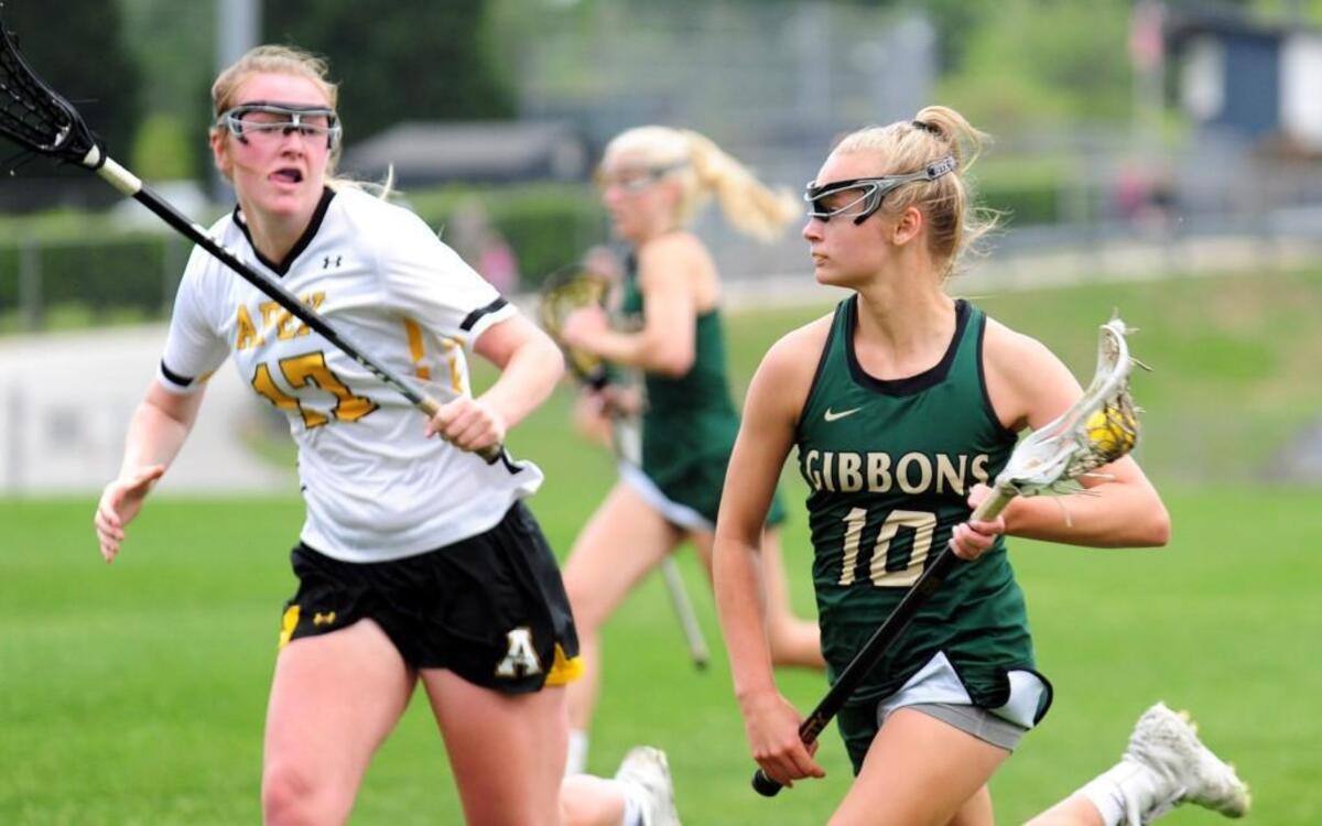 Apex's Paige Bracey (17) races with Cardinal Gibbons' Elizabeth Wilson (10) during the girls lacrosse playoff game, which took place in Apex on Friday, May 12, 2017. Cardinal Gibbons won 17-4.