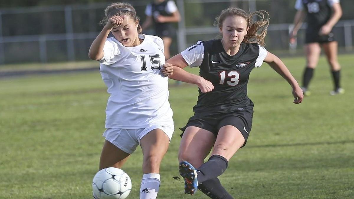 Middle Creek's Mattie Murphy slips this shot past Wakefield's Sierra Lowery (15) and into goal to put the Mustangs up 2-0 midway through the first half. Coverage from 2nd round of the 4A NCHSAA Girls Soccer playoffs between the Middle Creek Mustangs and the Wakefield Wolverines played in Raleigh, N.C. on Saturday, May 13, 2017. Middle Creeks defeats Wakefield 2-1 to advance to the third round of the playoffs.