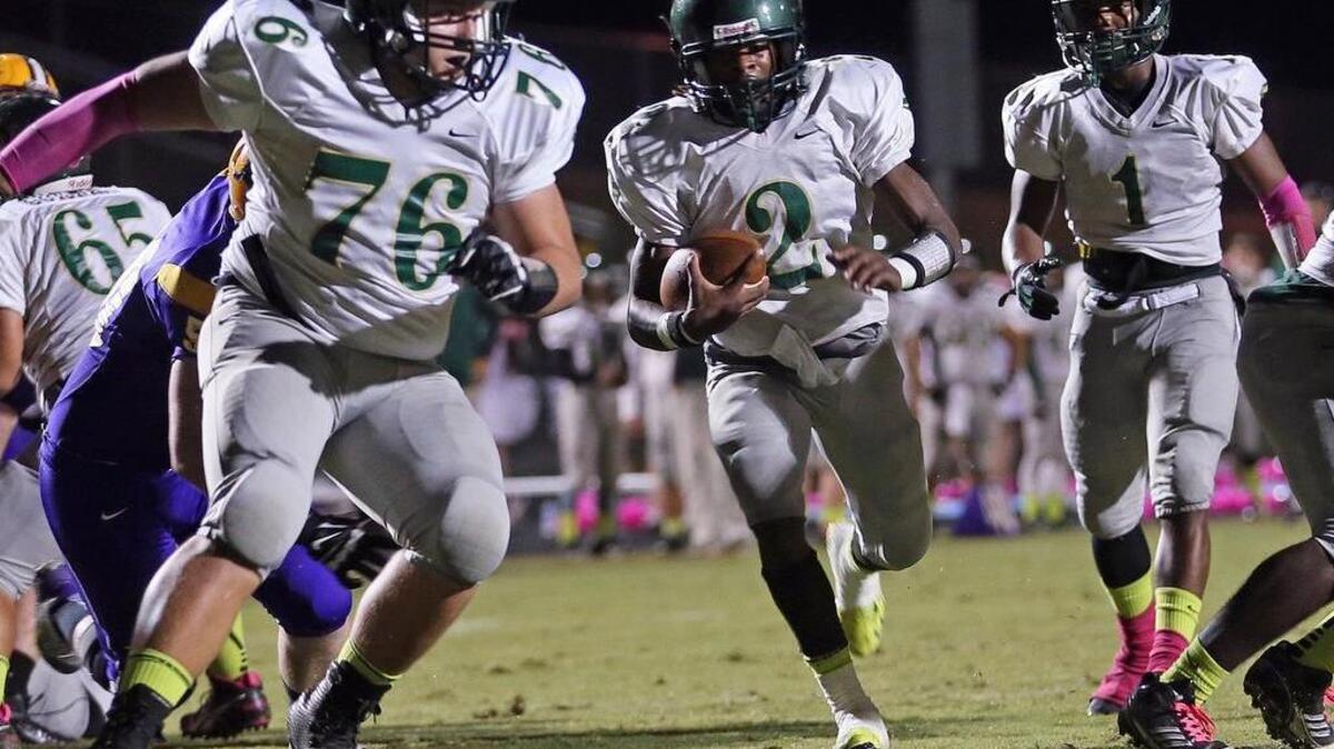 
South Johnston High’s Deparis Patterson (2) gets through a big hole created by teammate Josh Bradshaw (76) for the Trojans' second touchdown. The South Johnston High School Trojans defeated the Pirates of Corinth Holders High School 26-7 played in Archer Lodge, N.C. on Friday, October 17, 2014.
