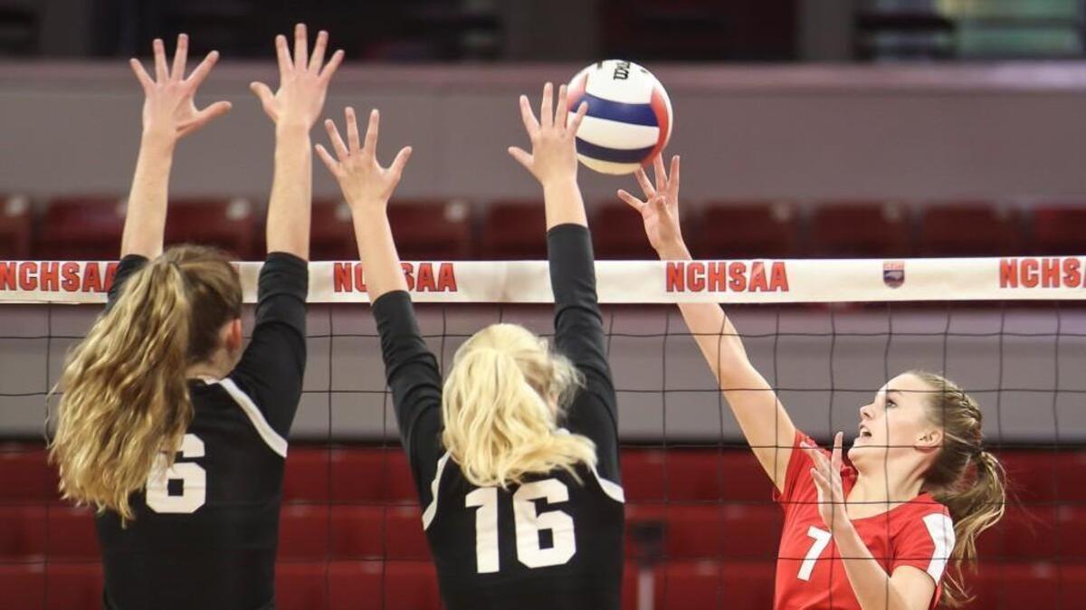 Roxboro's Kenley Long (7) dinks the ball over the block of CSD's Shea Aichele (6) and Liza Mitchell (16). The Community School of Davidson Spartans played against the Roxboro Community Bulldogs in the high school NCHSAA 1A State Championship volleyball game on Nov. 4, 2017.