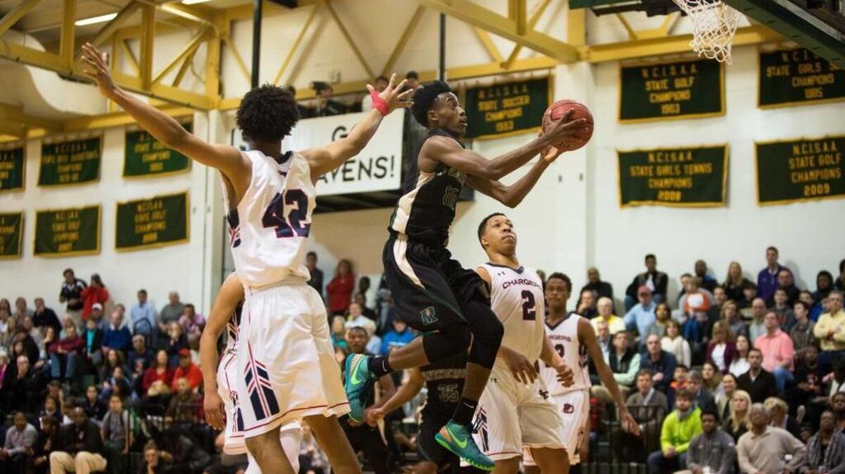 Ravenscroft’s Michael Okauru (10) attempts a shot as Providence Day School’s Joshua Howard (42) and Providence Day School’s Grant Williams (2) defend during a high school basketball game in Raleigh, N.C. on Friday, Feb. 19, 2016.