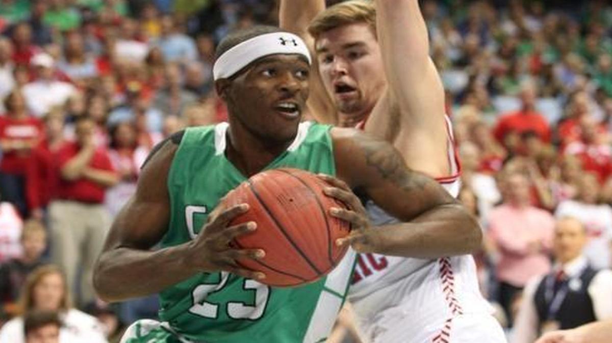 Cary's Donte Tatum (23) drives around Charlotte Catholic's Jack Larkin (5) during the 4A State Basketball Championship game with the Cary Imps high school against Charlotte Catholic on March 12, 2016 , Chapel Hill, N.C. Charlotte Catholic won the game 49-46.