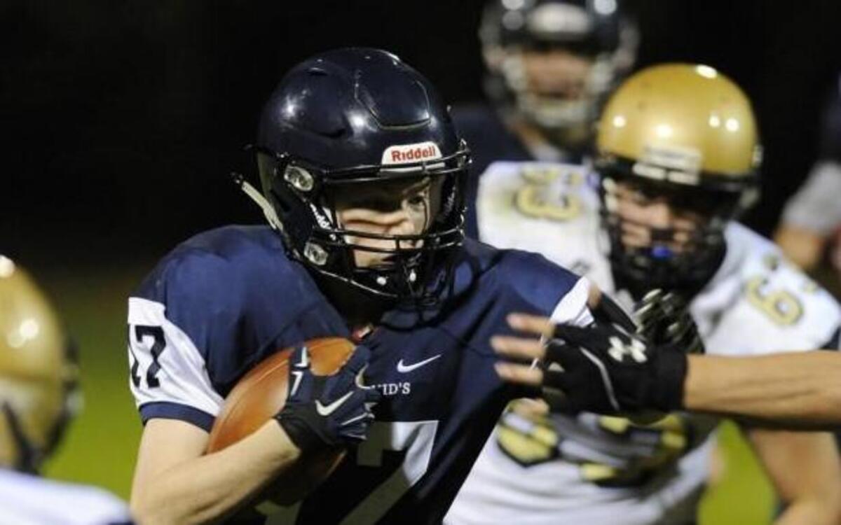 St. David’s School’s John Mac Feeney (17) stiff arms Cary Christian’s Bryan Hellman (33) in Raleigh on Friday. St. David’s remained undefeated.