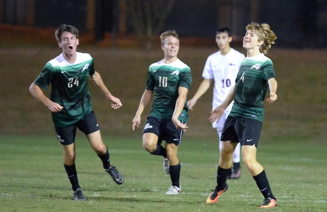 Jackson Hollenbach (4) of Cardinal Gibbons celebrates his goal along his teammates Nelson Zimmerman (10) and Nicholas Brassington (24). The Jordan Falcons played the Cardinal Gibbons Crusaders in a boys soccer game that took place in Durham, N.C. on Monday, October 17, 2016. Cardinal Gibbons won 4-3.