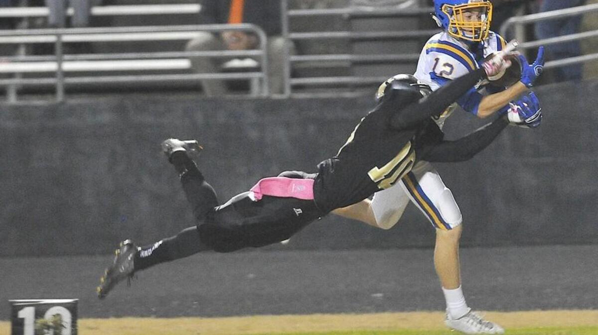 Garner’s Justin Gahrmann (12) makes catch while covered by Knightdale's Joshua Jones (10).The Garner Trojans took on the Knightdale Knights in football at Knightdale High in Knightdale, N.C. on Friday, October 23, 2015.