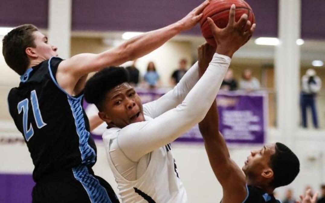 Heritage's Jayden Gardner (40), center, receives a pass into the post while being defended by Millbrook's Patrick Dorsey (21) and Adrian Scarborough (24) during the CAP-8 boys basketball tournament championship between Heritage and Millbrook on Friday, February 17, 2017. Millbrook won the game 57-54.