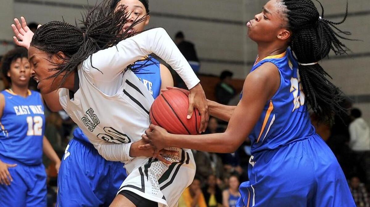 East Wake's Mikieja Covington (22) ties up the ball with Southeast Raleigh's Leikhiya McClenningham (30) during the second half. The East Wake Warriors took on the Southeast Raleigh Bulldogs in basketball in Raleigh, N.C. on January 8, 2015. East Wake wins 52-46.