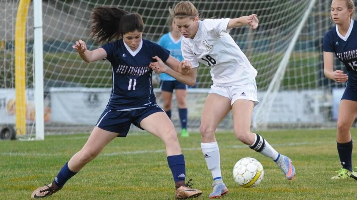 Apex Friendship's Lilly Fox (11) and Apex's Madeline Uenking (18) vie for the ball during the girls soccer game, which was played in Apex on Wednesday, March 9, 2016. Apex won 2-1.