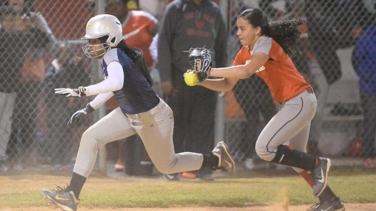 Hadiyah Omar, left, of Hillside runs to the home base against the pursuit of Siena Oyan, right, of Southern. The Hillside Hornets played the Southern Durham Spartans in a softball game that took place in Durham, N.C. on Thursday, March 9 2017. Southern Durham won 30-20.