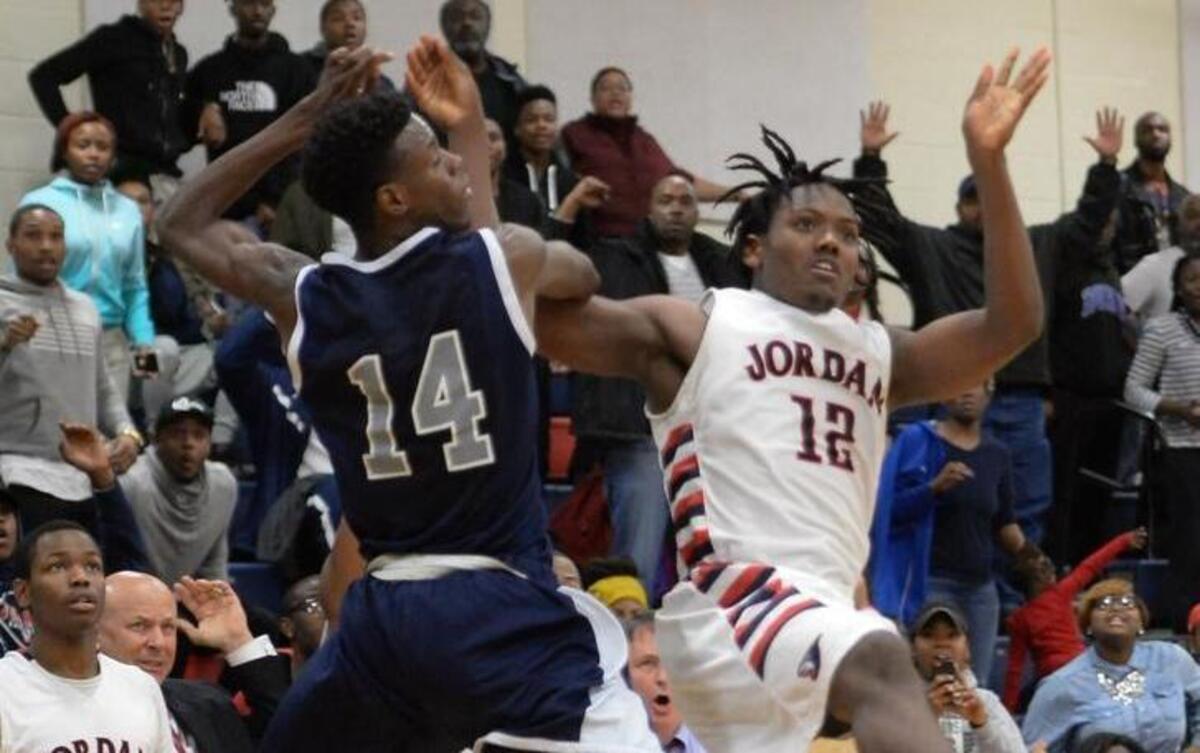 Cheo Craig (12) of Jordan gets fouled in the last second of the game by Deiontae Ray (14) of Hillside. The Jordan Falcons played the Hillside Hornets in Durham, N.C. on Friday, January 8, 2016. Jordan won 58-57.