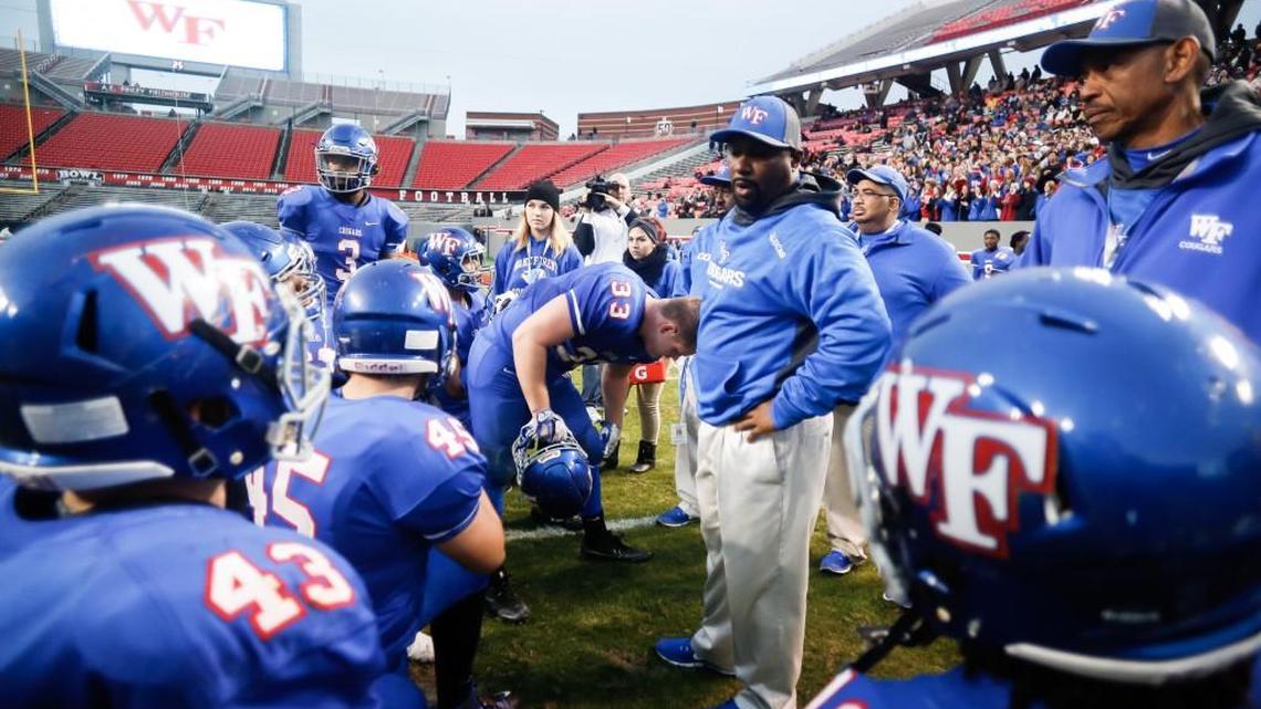 Wake Forest head coach Reggie Lucas talks to his players before they take the field following halftime of the NCHSAA 4AA football championship game between Page and Wake Forest in Raleigh on Saturday, December 17, 2016. Wake Forest won the game 29-0.