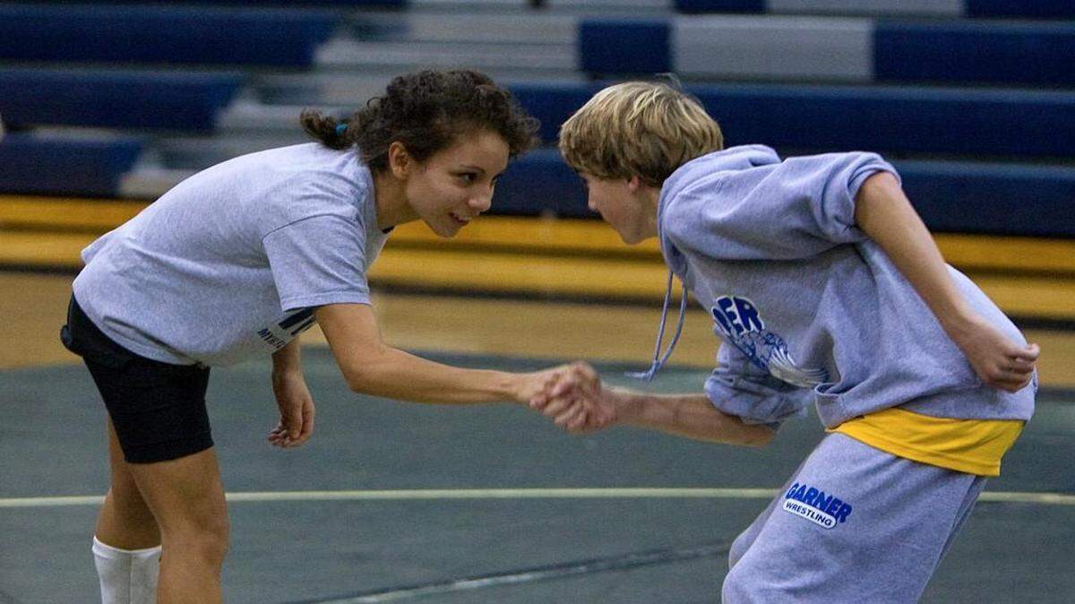 Knightdale High School female wrestler Jahamancely (cq) Cruz, left, shakes hands with her opponent, Will Pittman from Garner, before a match held at the school in Kightdale Wednesday night Dec. 17, 2008.