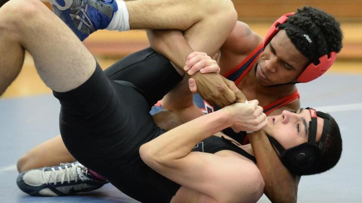 Dwayne Odom, left, of Jordan wrestles Christopher Hutton, right, of East Chapel Hill at 126 lbs during the dual team match between the East Chapel Hill Wildcats and the Jordan Falcons in Durham, N.C. on Wednesday, December 2, 2015.