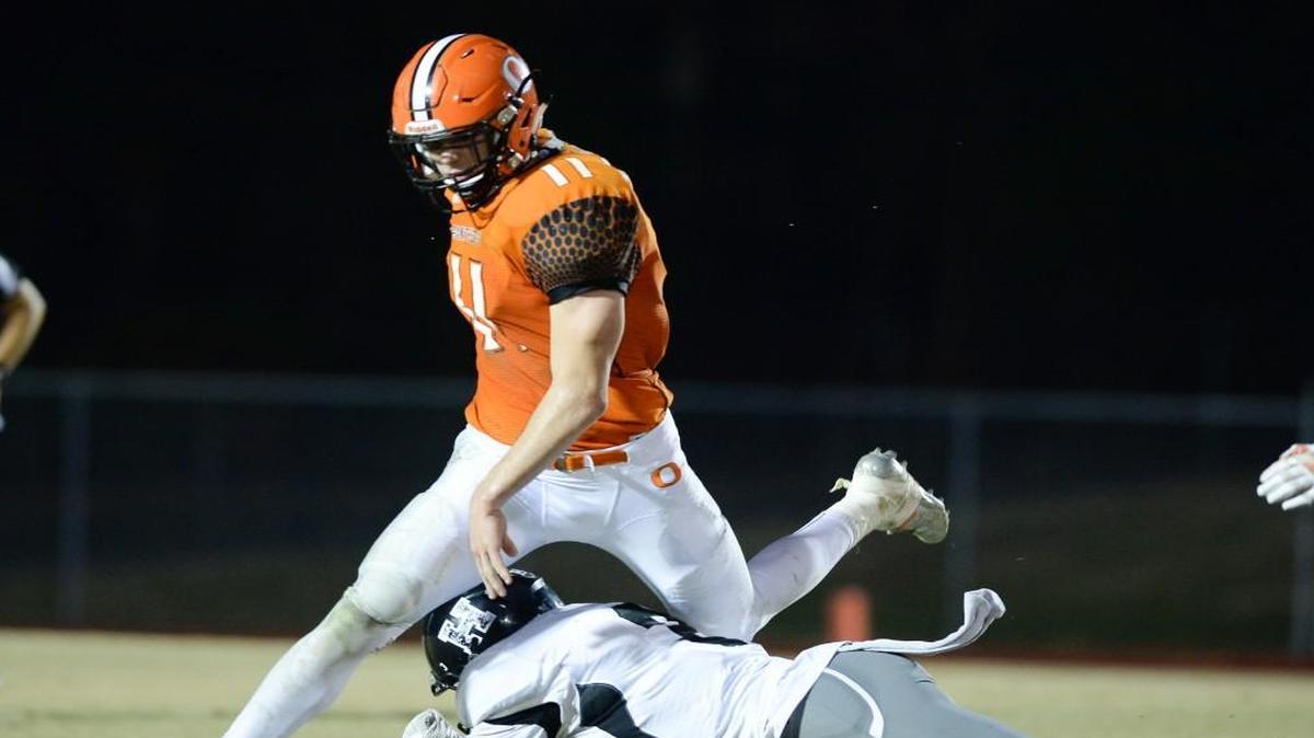 Payton Wilson (11) of Orange moves the ball against a tackle from Jeffrey Harris, right, of Havelock. The Orange Panthers played the Havelock Rams in a football game that took place in Hillsborough, N.C. on Friday, November 25, 2016. Havelock won 14-7.