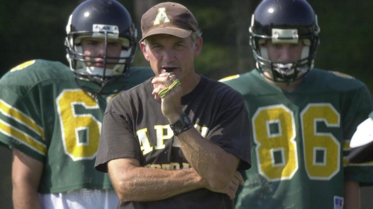 Apex high head football coach Bob Wolfe has built up his program gradually over the past eight years into several winning seasons. He keeps a close eye on his offense during a Sept. 6, 2001 practice.