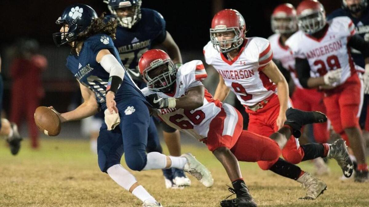 Sanderson's Adoza Umaru (66) sacks Millbrook's quarterback Ford Werness (10) during CAP-8 4A matchup between Sanderson and Millbrook that took place at Millbrook High School on November 4, 2016 in Raleigh, North Carolina.