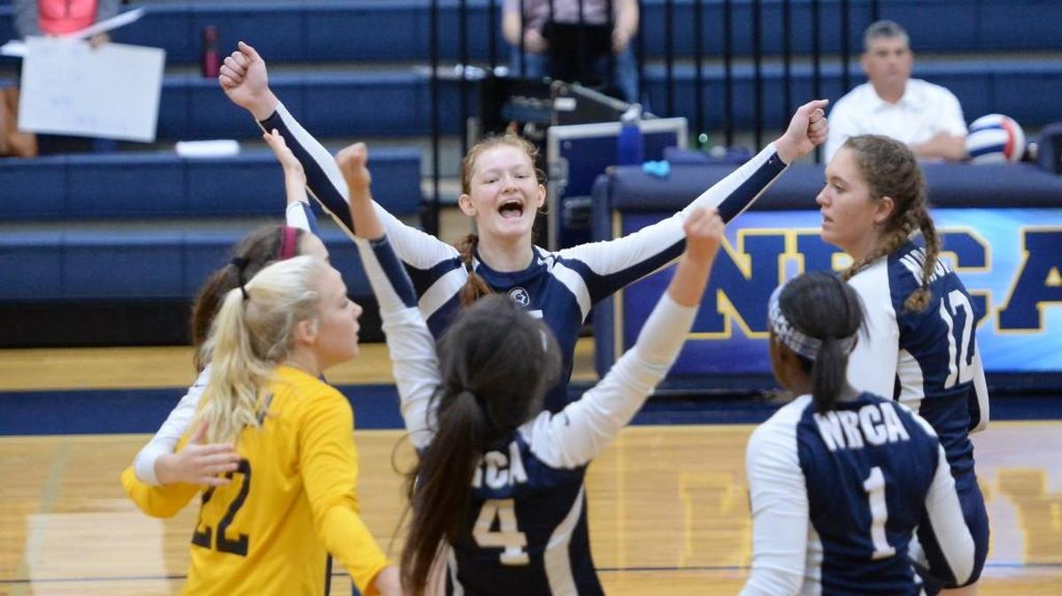 Lauren Janok, center, of North Raleigh Christian Academy celebrates along her teammate after scoring a point. The North Raleigh Christian Academy Knights played the High Point Christian Academy Cougars in a volleyball game that took place in Raleigh, N.C. on Saturday, October 29, 2016. North Raleigh Christian Academy won 3-0.