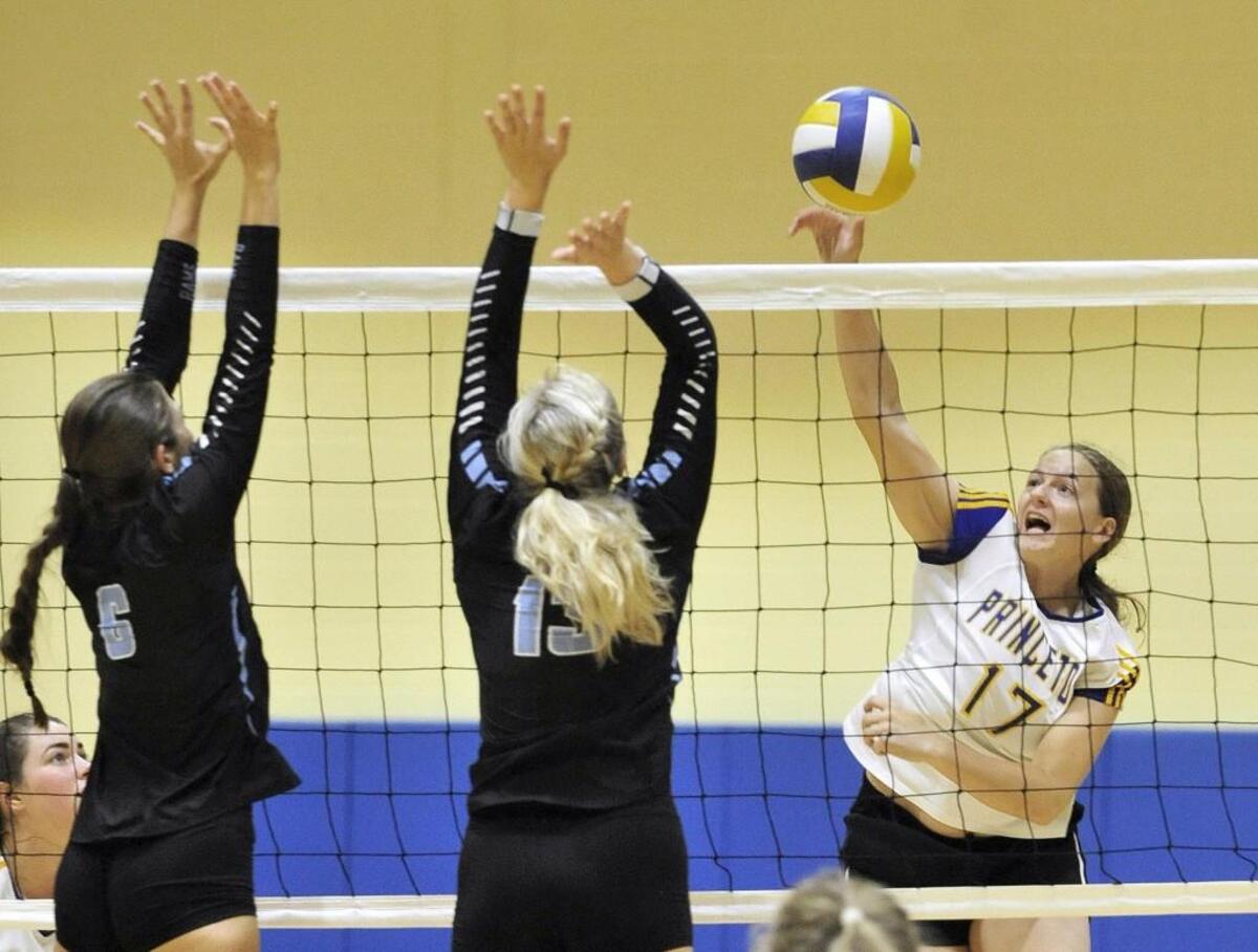 Princeton’s Emily Ricks (17) fires off a slam against Cleveland’s Ashley Talbot (6) and Taylor Woods (13).