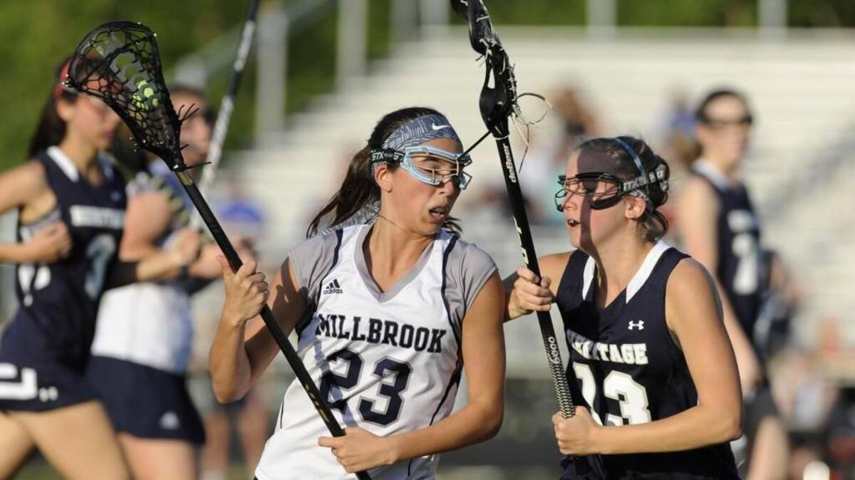 Millbrook's Dana Florian (23) drives past Heritage's Callie Gillespie (13) in Raleigh, N.C. on Tuesday, April 19, 2016. Millbrook won 20-6.
