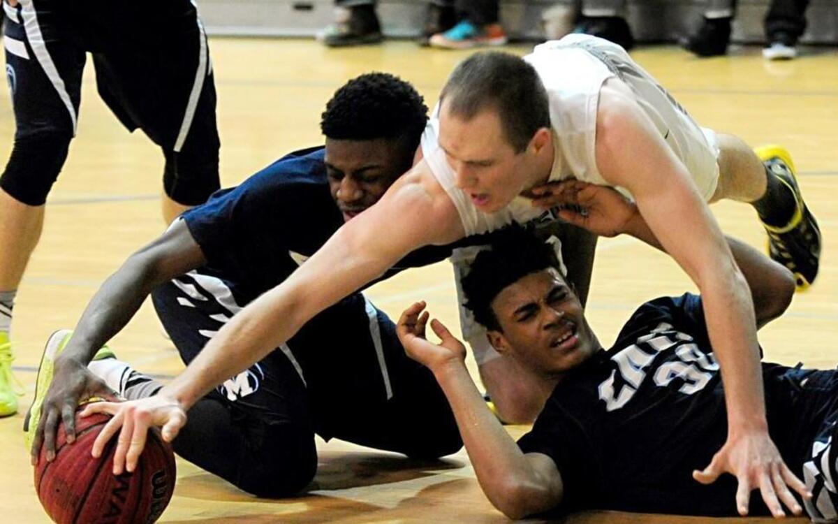 Heritage's Ian Hinkley (center) battles for a loose ball with Millbrook's Gee Kalejaiye (left) and Trejon Jacob (30) during the boys basketball game, which was played on Friday, January 8, 2016 in Wake Forest. Heritage won 96-85.