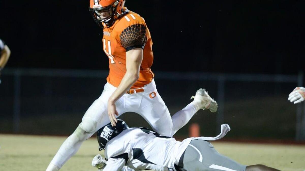 Payton Wilson (11) of Orange moves the ball against a tackle from Jeffrey Harris, right, of Havelock. The Orange Panthers played the Havelock Rams in a football game that took place in Hillsborough, N.C. on Friday, November 25, 2016. Havelock won 14-7.