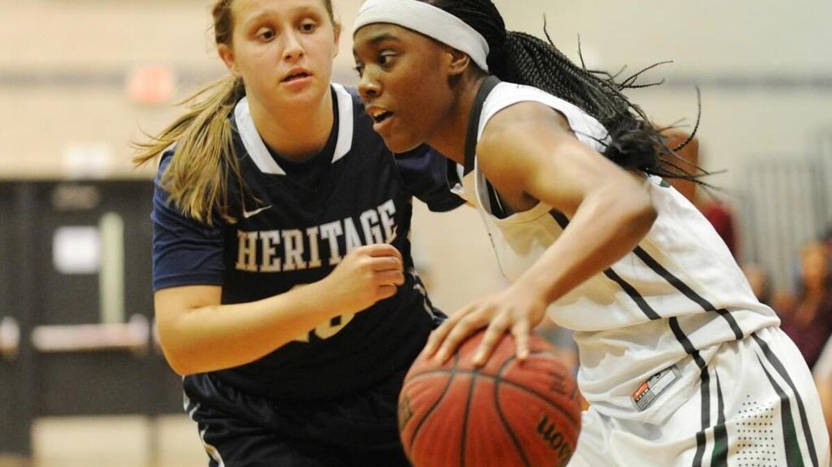 Southeast Raleigh's Tamia Davis (right) pushes past Heritage's Alana Brown during the girls basketball game, which was played in Raleigh on Saturday, November 26, 2016.