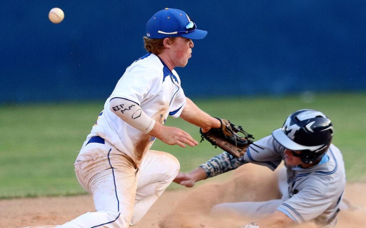 
Millbrook High baserunner Bryce Carnevale (20) slides safely into second base as the ball gets by Garner second baseman Nick Gallogly (1). Carnevale started a 4 run inning that put Millbrook up 5-1 in the top of the 5th. The Garner High Trojans face off against the Millbrook Wildcats in the 3rd round of the Eastern 4A NCHSAA baseball tournament played in Garner, N.C. on Tuesday, May 19, 2015.
