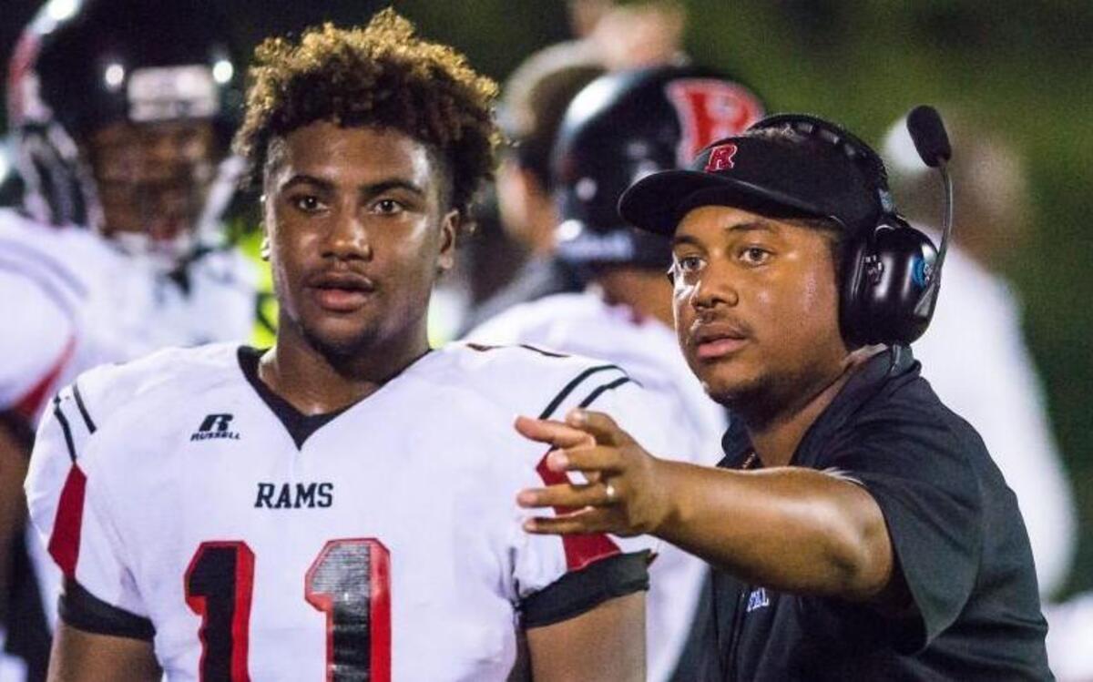 Rolesville’s Carnaji Andrews (11) talks with head coach Jermaine Evans during a football game played at Enloe on Thursday, Sept. 4, 2015. Rolesville won 34-6.