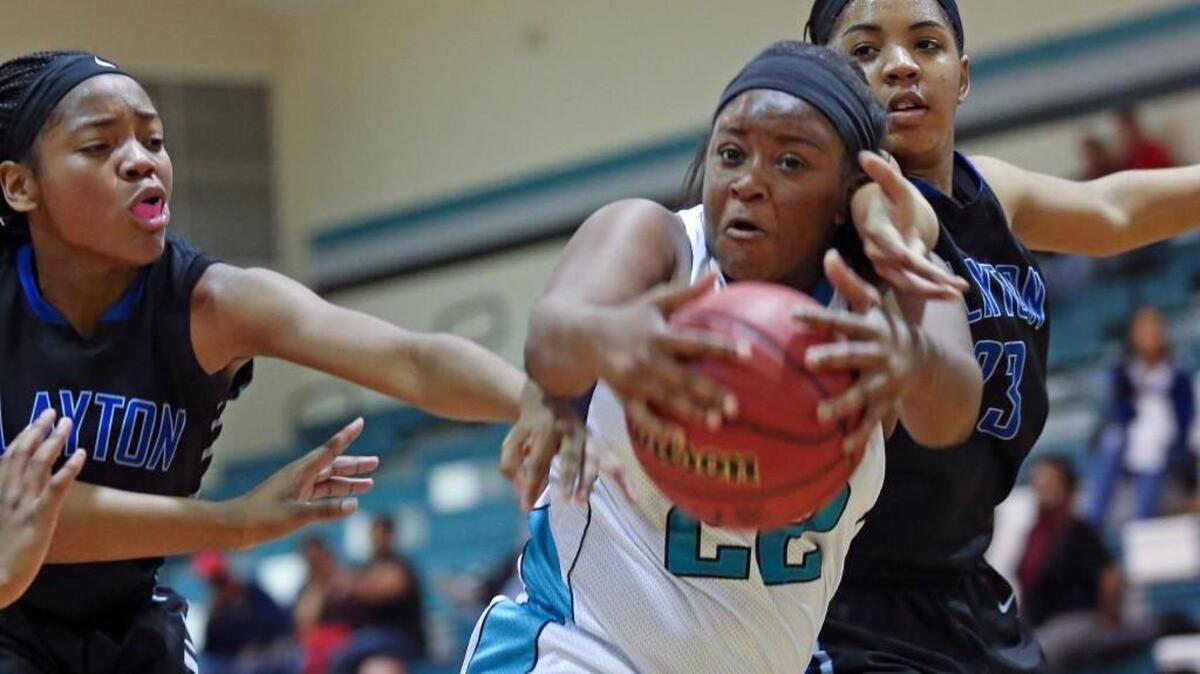 West Johnston's Courtney Creese (22) pulls in a rebound between Clayton's Jasmine Carter (23) and Asia Todd (5). Coverage from the boys and girls basketball games between the Comets of the Clayton High and the Wildcats of West Johnston High played in Benson, N.C. on Friday, January 8, 2016. The Clayton girls won 46-40 in overtime.