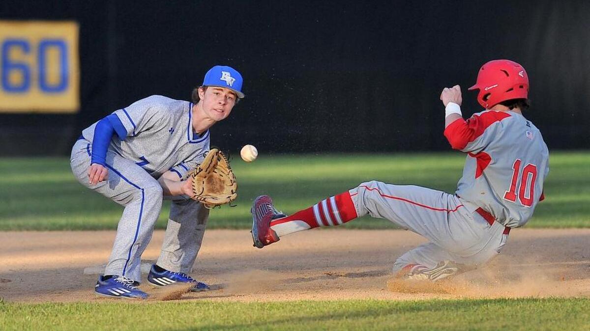Sanderson’s Ray Stocum (10) slides into second base beating the throw to East Wake’s Trevor Creech (7). The Sanderson Spartans took on the East Wake Warriors in baseball at East Wake in Wendell, N.C. on March 9, 2016. Sanderson wins 17-7.