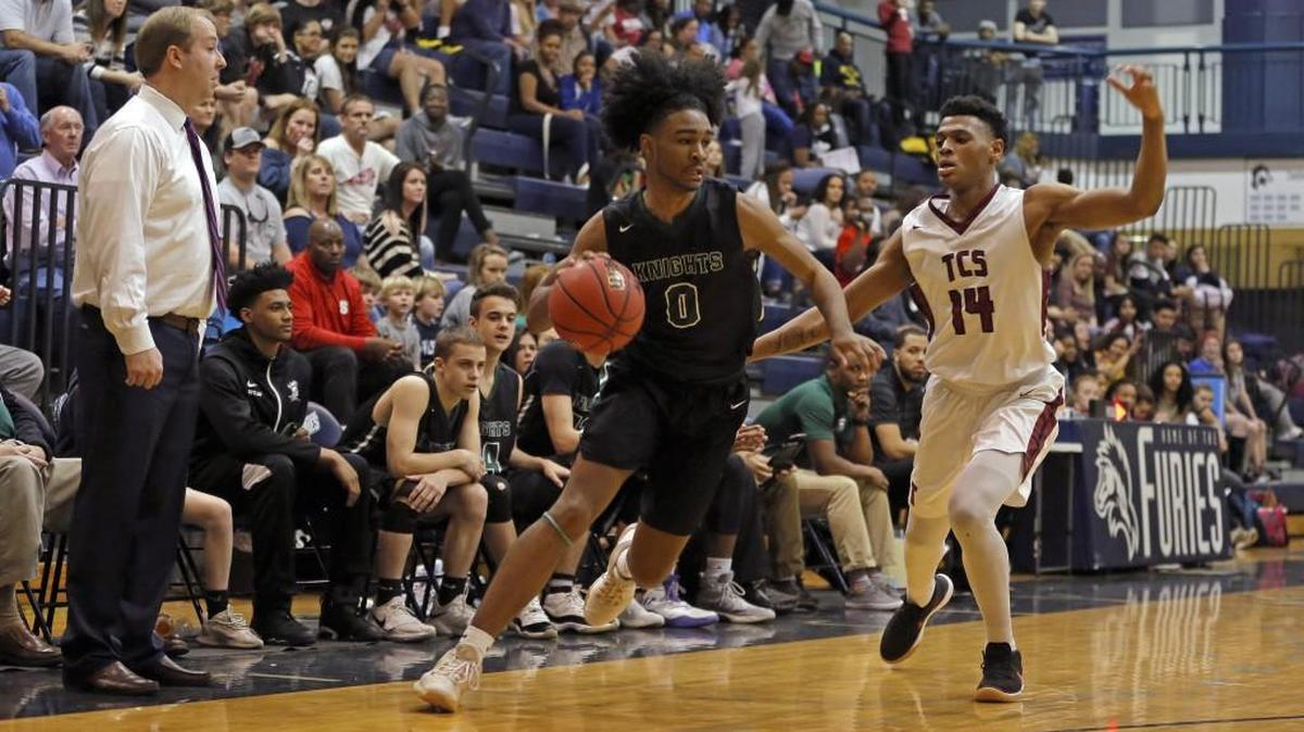 Greenfield's Coby White (0) dribbles the basketball down the sideline past Trinity Christian School's Au'diese Toney (14).