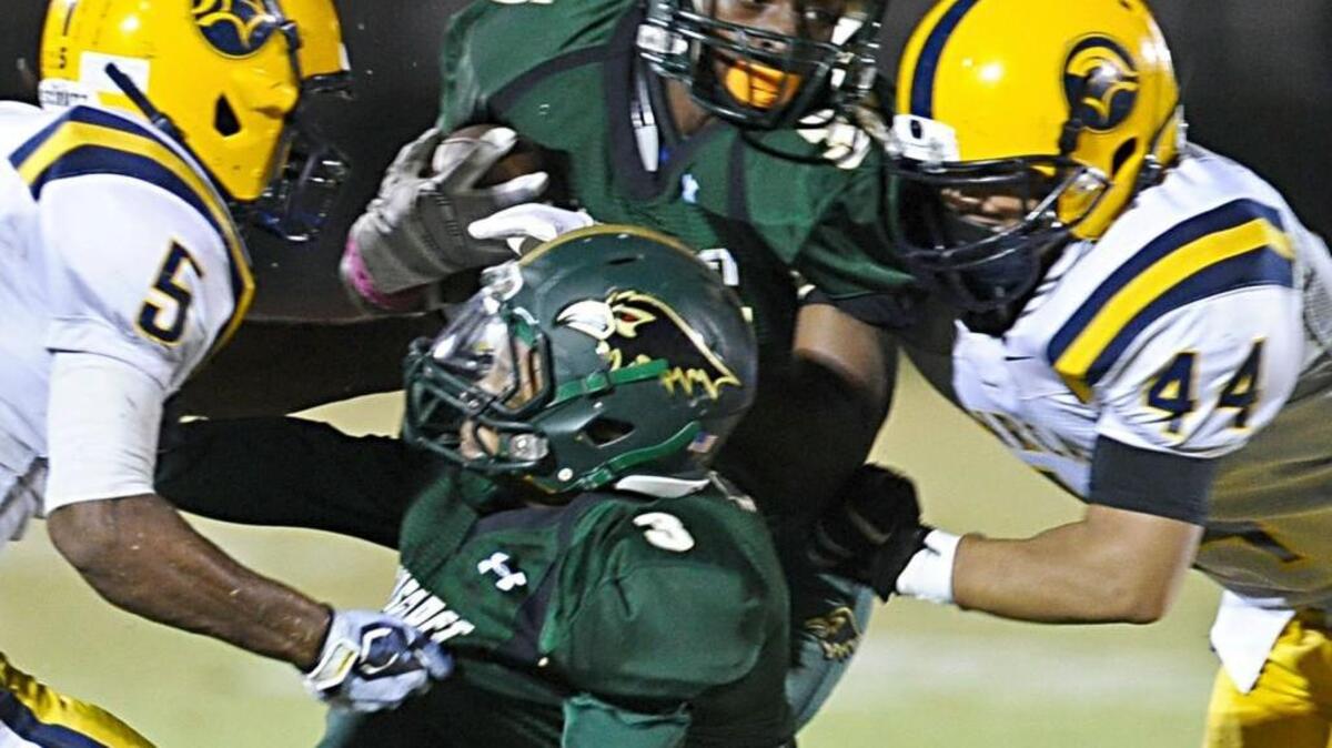 Ravenscroft’s Kenny Bowling (15) is brought down by North Raleigh Christian's Tyree Hawkins (5) and Jalen Brooks (44) during the football game, which was played on Friday, October 16, 2015 in Raleigh.