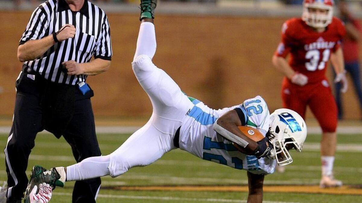 J.H. Rose running back Dontavies Harris balances himself on his left hand after being tripped by a Charlotte Catholic defender during the NC 4A football championship game at BB&T Field in Winston-Salem, NC on Saturday, December 12, 2015.