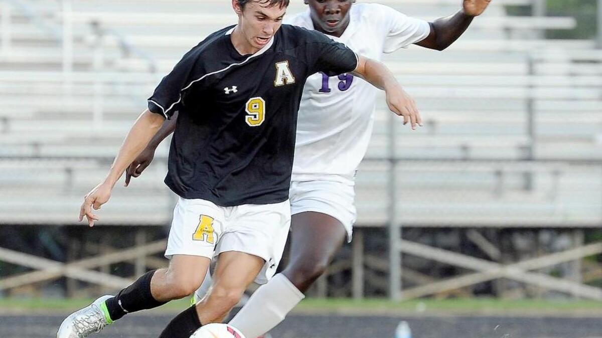 Apex’s Will Tomlinson (9) and Holly Springs' Brent Mahasi (19) vie for the ball during the boys soccer game in Holly Springs on Tuesday, September 8, 2015.