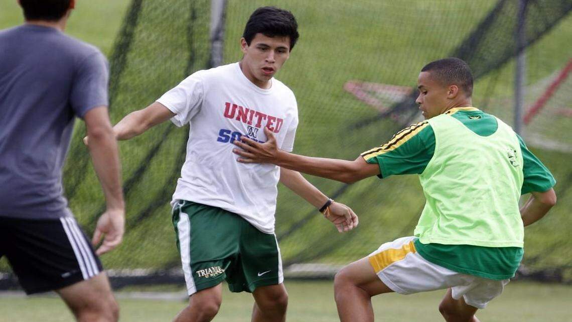 CHHS forward Matthew Ortez (cq), center, scrimmages against defenseman Paul McLaughlin, right, on the CHHS practice soccer field Thursday, July 31, 2014 during this week's Monday-Friday morning annual CHHS soccer camp.