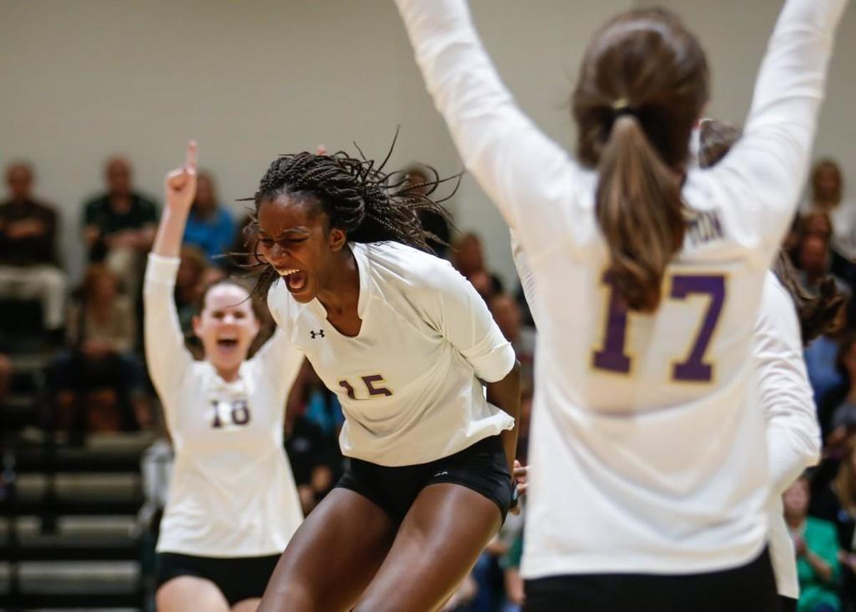 Broughton's Jade Demps (15) celebrates an overtime point with teammates Grace Youngblood (18) and Nan Parrish (17) during Broughton's volleyball game at Cardinal Gibbons on Saturday, October 29, 2016. Broughton won the game 3-2.
