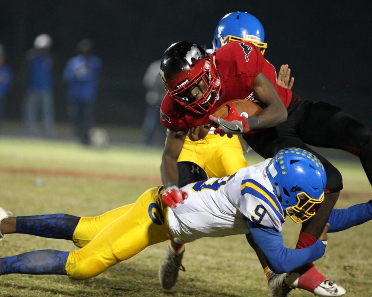 Garner's Laytavion Haywood (9) tackles Middle Creek's Jordan Mitchell (21). The Garner Trojans visited the Middle Creek Mustangs in a high school football game on Nov. 3, 2017.