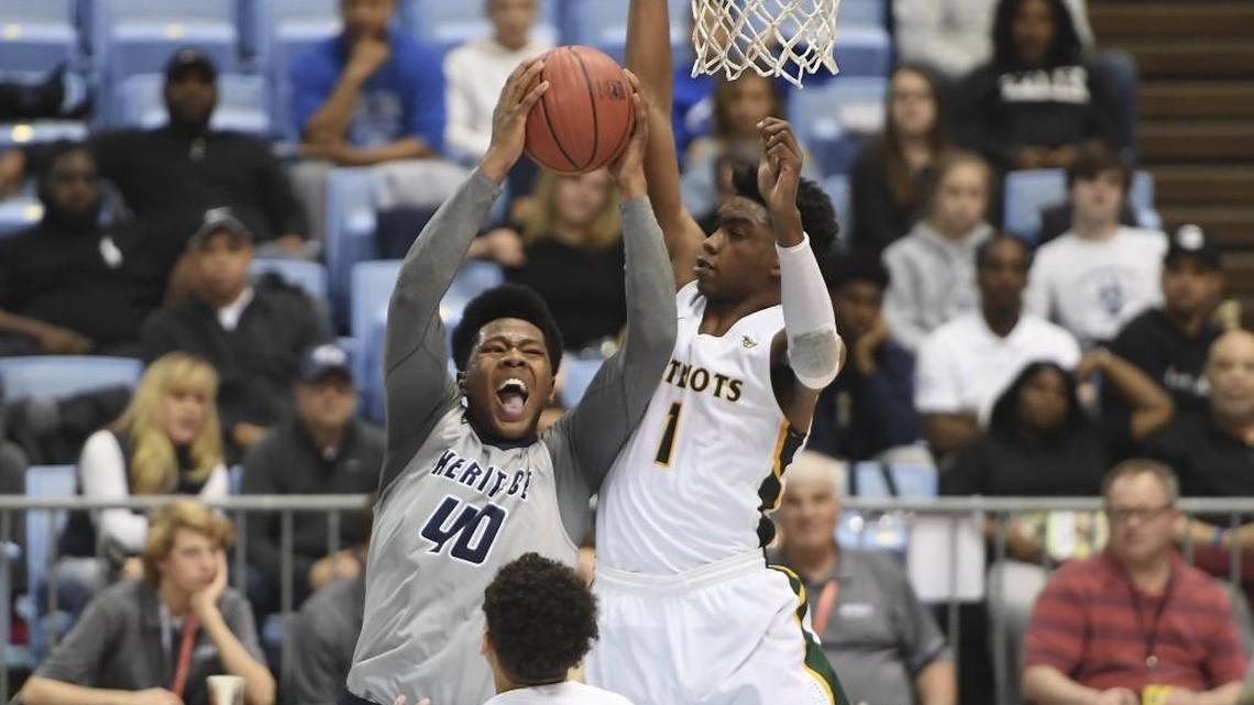 Jayden Gardner (40) of Heritage drives to the basket against Matt Smith (1) and Miles Pauldin (10) of Independence. The Heritage Huskies played the Independence Patriots in a boys basketball game that counted for the NCHSAA 4A championship that took place at the UNC Dean Smith Center in Chapel Hill, N.C. on Saturday, March 10, 2018. Independence won 71-60.