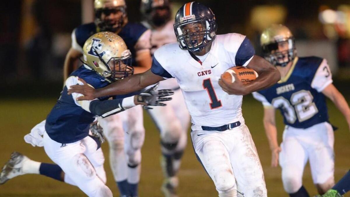 Ishois Times, right, of Southern Lee avoids a tackle from Justin Bethea, left, of Lee County to break free for a touchdown run in the first half. The Southern Lee Cavaliers played the Lee County Yellow Jackets in Sanford, N.C. on Friday, November 6, 2015. Southern Lee won 21-20 in overtime.