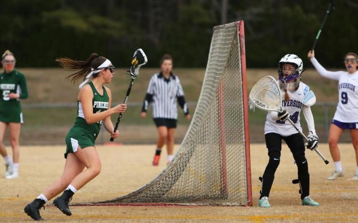 Pinecrest attacker Haley Dick (14) rounds the goal before scoring her team's sixth point during the Pinecrest Patriots' 13-3 win over the Riverside Pirates at Riverside High School in Durham, N.C., Friday, March 17, 2017.