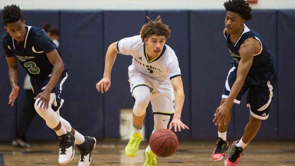 Millbrook's Jordan Whitfield, middle, dribbles the ball as Leesville's Alex Hunter (3) and Oliver Yellock, right, defend during a high school basketball game in Raleigh, N.C. on Thursday, Jan. 21, 2016. Millbrook enters the playoffs as the No. 1-ranked team in the N&O area rankings.