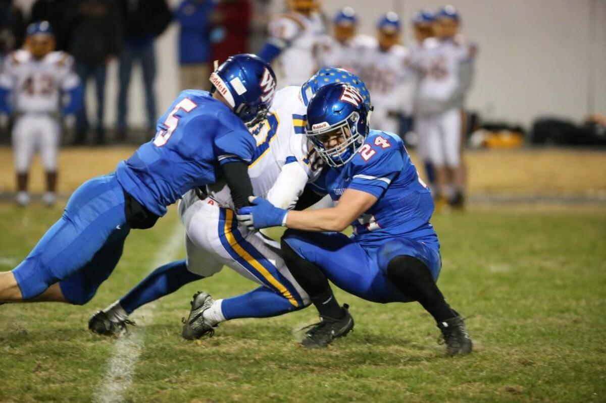 Wake Forest's Drew Homschek (5) and Connor Loeffler (24) tackle Garner's Jaydin Dixon (10). The Garner Trojans visited the Wake Forest Cougars in the 4AA East final in the NCHSAA high school football playoffs on Dec. 1, 2017.